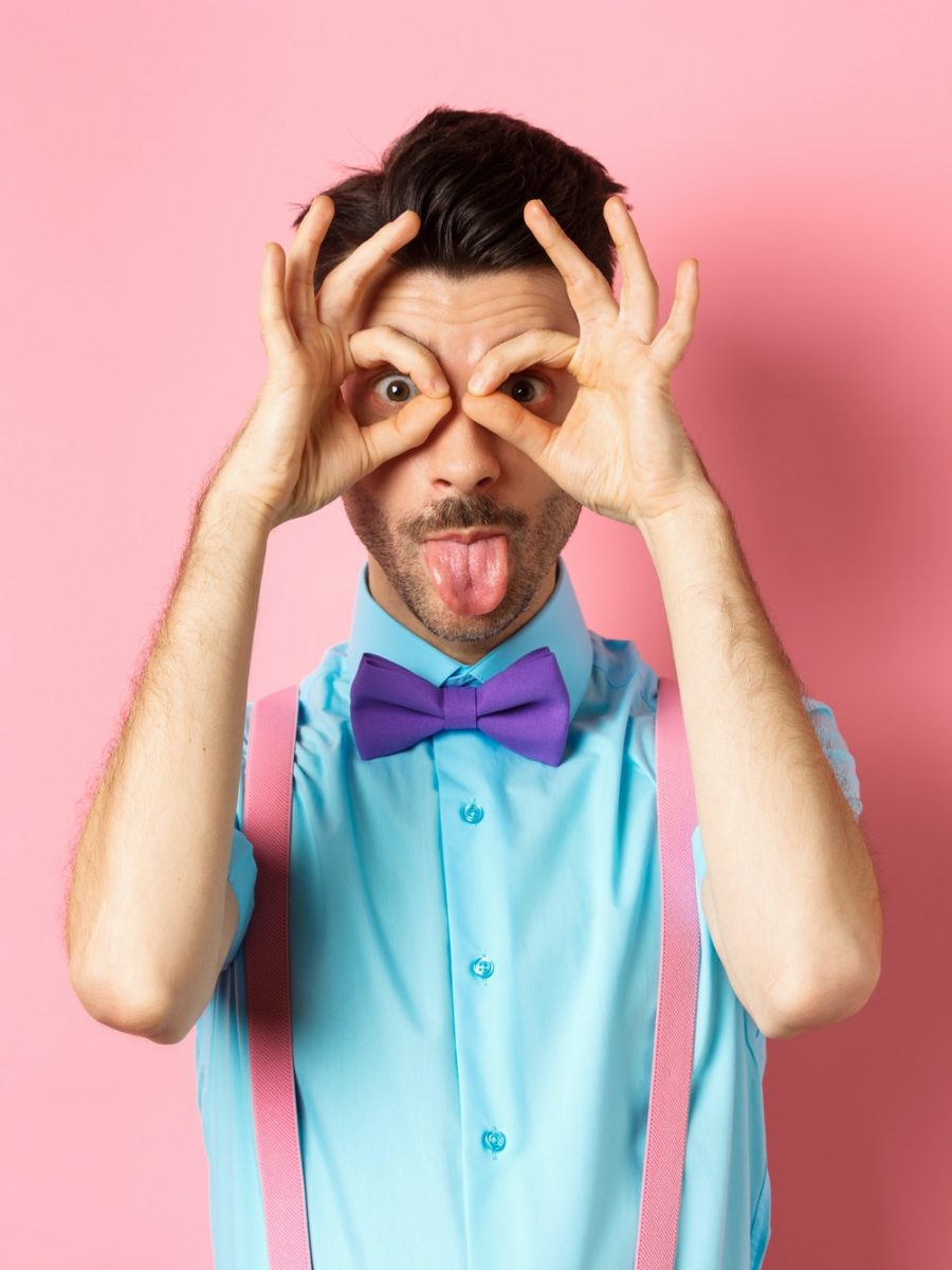 funny-and-silly-young-man-in-bow-tie-and-suspenders-looking-through-hand-binoculars-and-showing.jpg